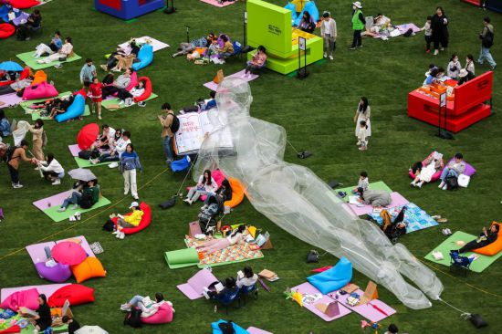 2023年4月23日，人們在韓國首爾廣場上閱讀和休息。新華社記者王益亮攝