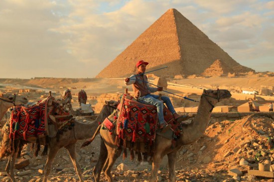 1月24日，商販騎駱駝離開埃及吉薩金字塔景區(qū)。新華社記者 隋先凱 攝
